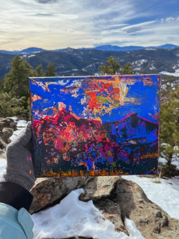 Bright blue, orange, and pink abstract painting with mountains in the distance